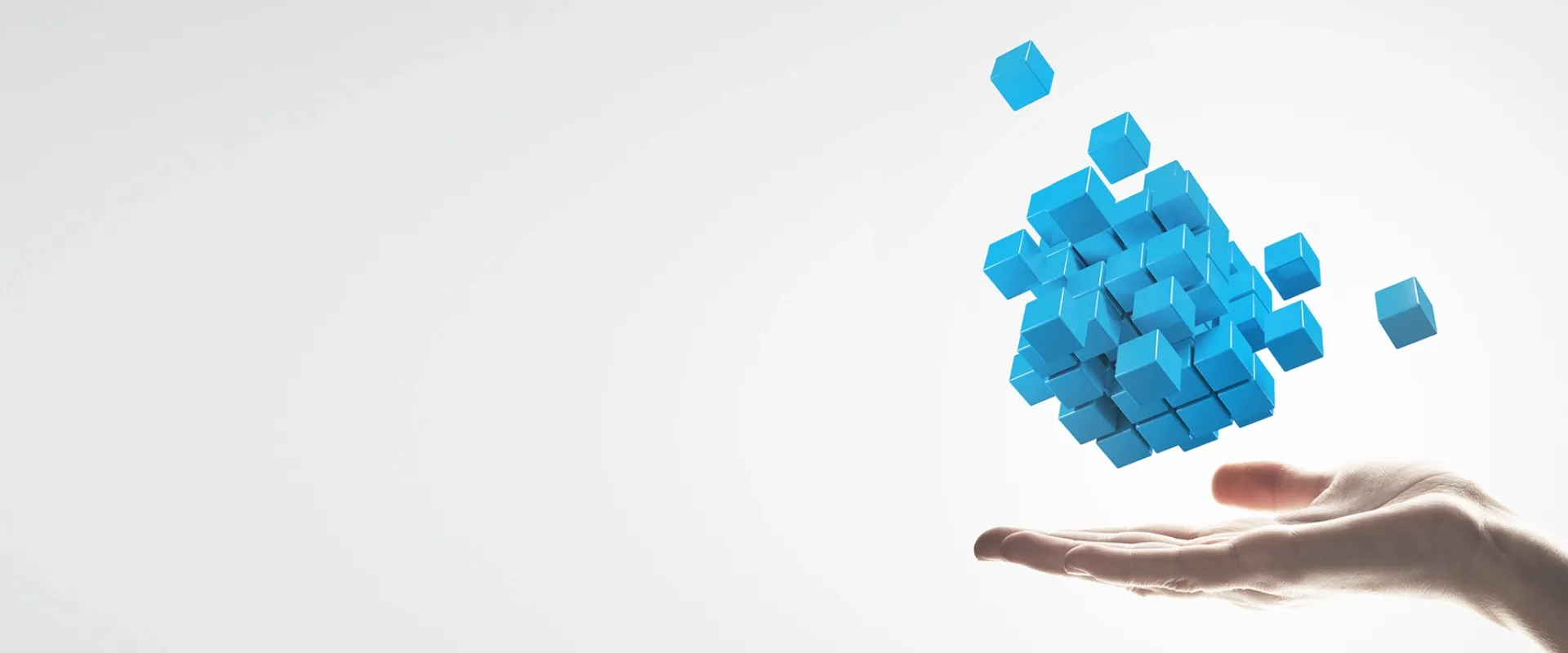 A hand presenting blue 3D digital blocks symbolizing Trinergy's innovative digital transformation