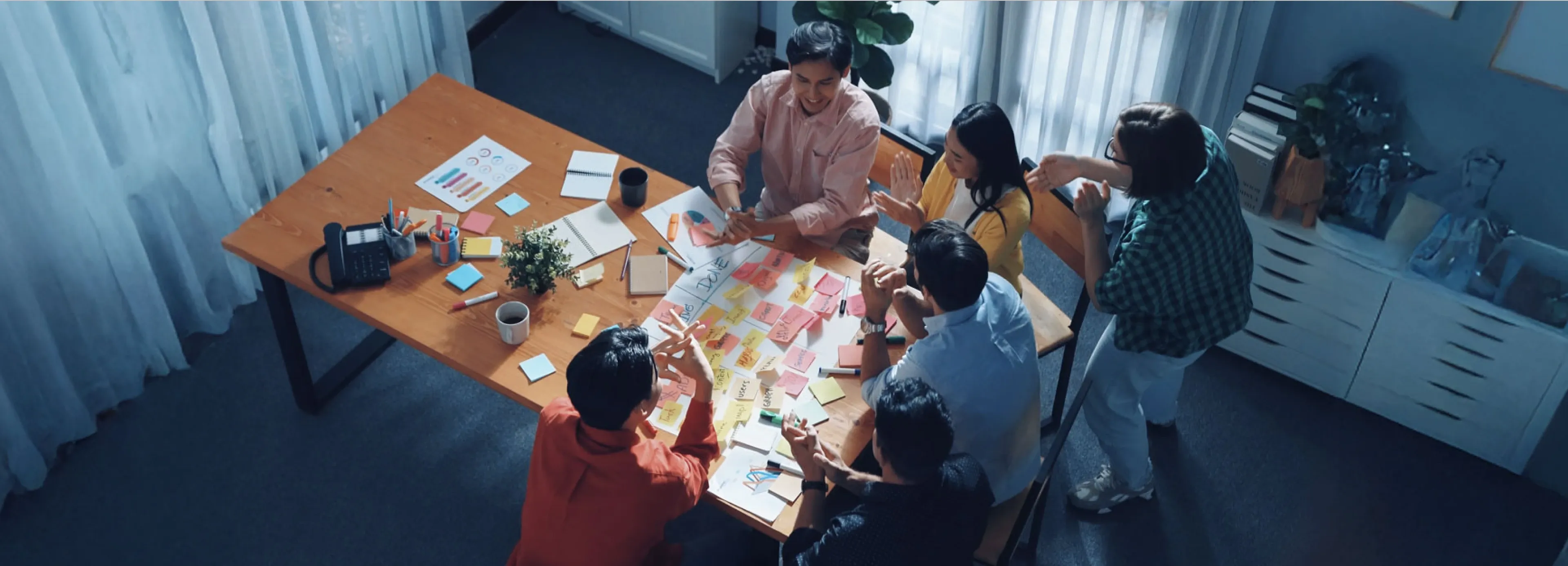 Team collaborating around a table covered with colorful sticky notes