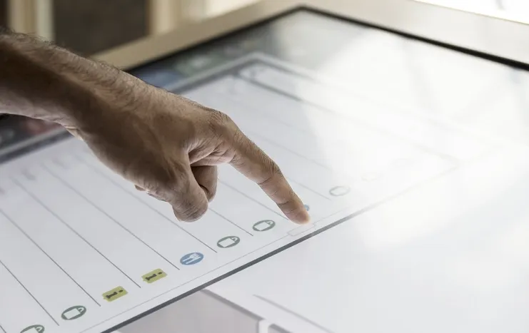 Close-up of a hand interacting with a touchscreen interface