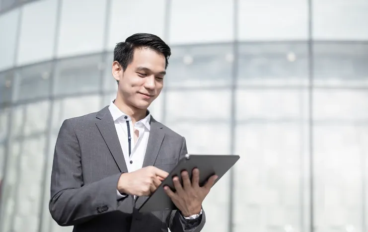 A business professional in a suit using a tablet