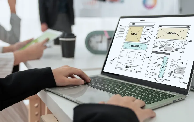 A website wireframe design displayed on a laptop