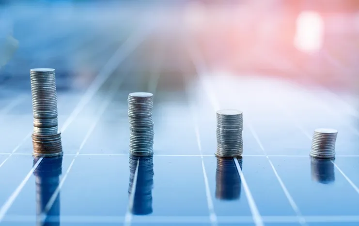 Stacks of coins arranged in ascending order on a reflective surface