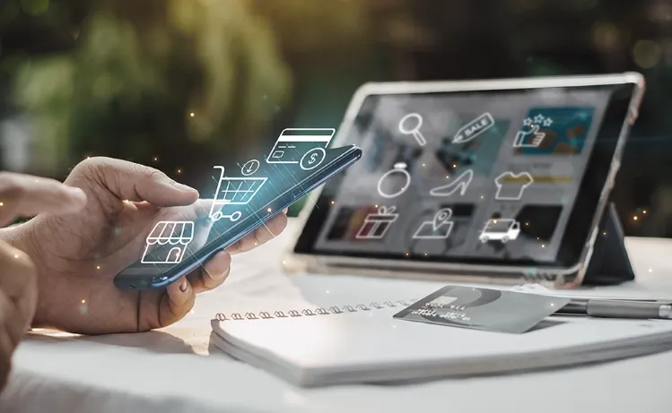 A person using a smartphone and tablet with holographic shopping icons