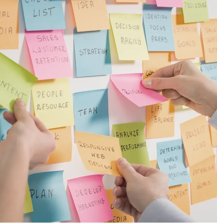 Hands placing sticky notes on a board