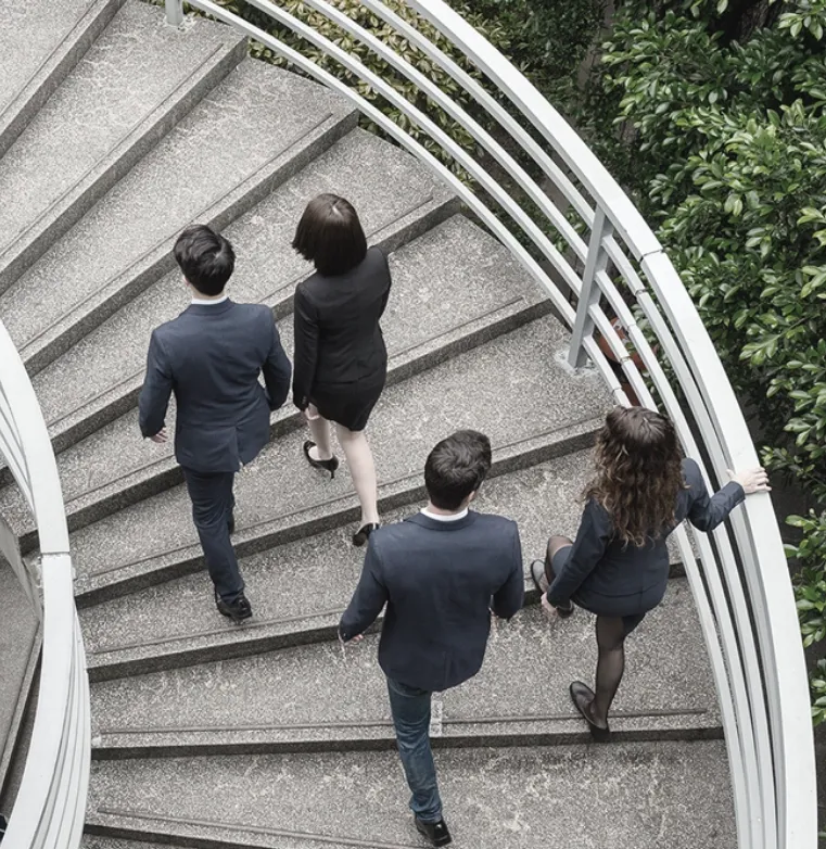 Trinergy team ascending a spiral staircase