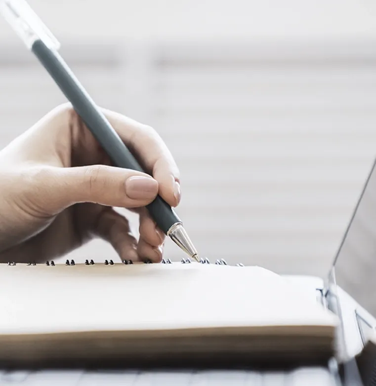 Close-up of a hand writing in a notebook