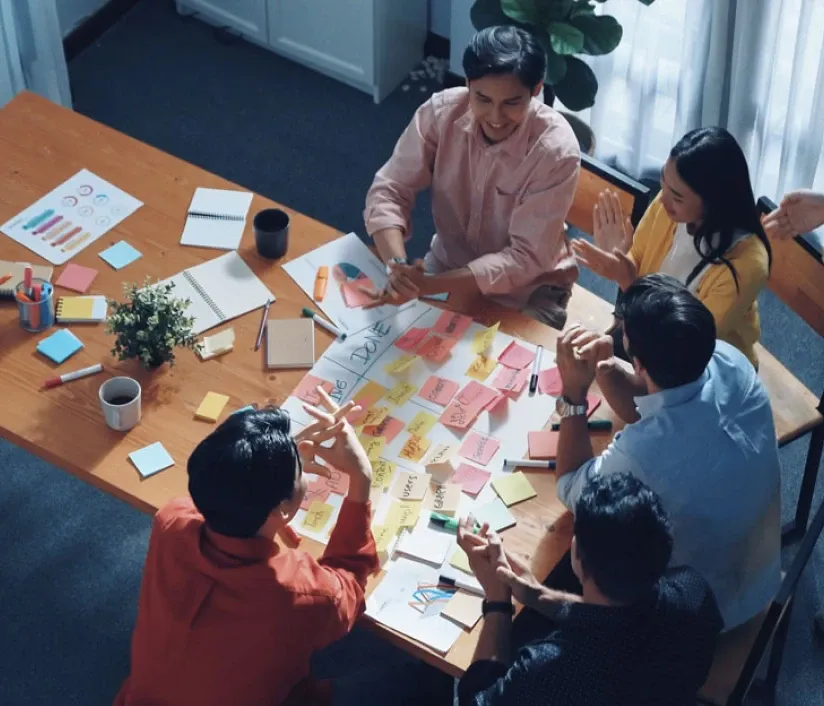 Team collaborating around a table covered with colorful sticky notes