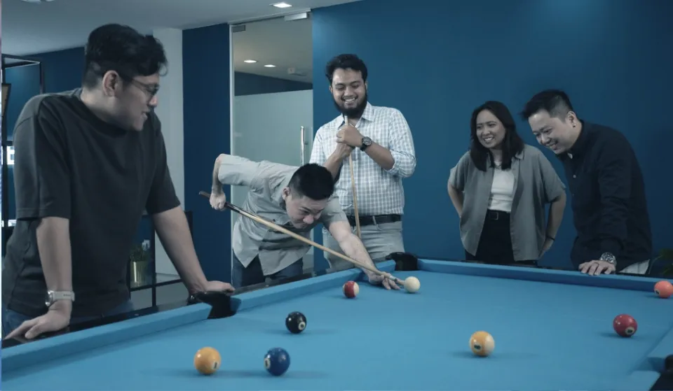 Trinergy colleagues playing pool during a team break