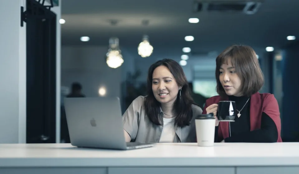 Colleagues sharing a friendly coffee conversation, representing Trinergy’s open and collaborative workplace culture.