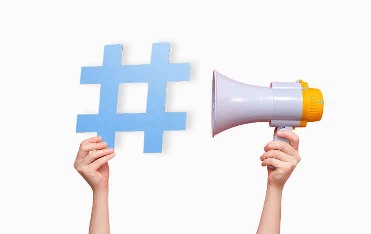 Trinergy social media marketing concept featuring a blue hashtag symbol and a megaphone, representing digital communication and brand promotion.