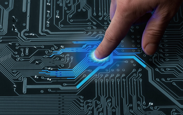A close-up of a finger interacting with a glowing circuit board, representing Trinergy's innovative approach to digital technology integration.